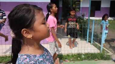 portrait of indonesian spoon marbles race during independence day, Batang Indonesia, August 17 2022