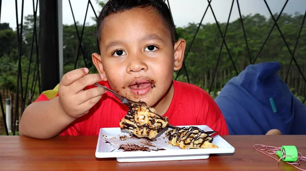 Asiatischer Junge Mit Schokolade Gesicht Der Kleine Rote Junge Isst — Stockfoto