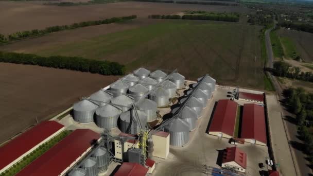 穀物貯蔵サイロ 穀物用の亜鉛メッキタンク 穀物出荷のための機械設備を持つ穀物 天気の良い日に移動中のトップビューショット — ストック動画