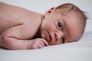 Beyaz bir çarşafın üzerinde iki haftalık, çok tatlı bir bebek. Yüksek kalite fotoğraf