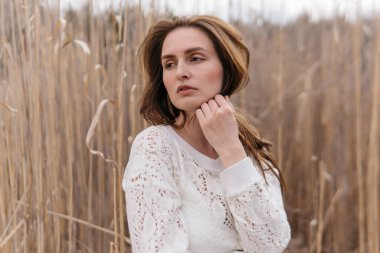 Beyaz elbiseli, bej ceketli, bahar huş ağacında bebeği olan genç ve güzel bir anne. Yüksek kalite fotoğraf