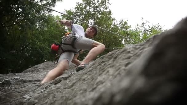 Man bergsklättring i vacker natur skott underifrån — Stockvideo