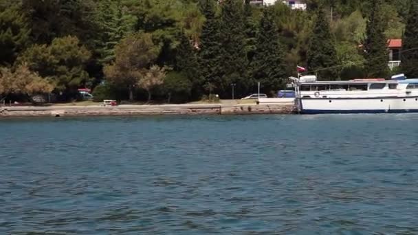 Aufnahme des am Ufer festgemachten Bootes. Schuss aus dem fahrenden Boot — Stockvideo
