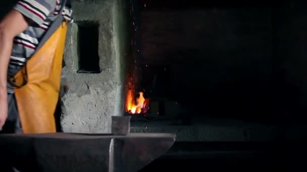 Blacksmith is blowing up air in the furnace to get sparkles — Stock Video