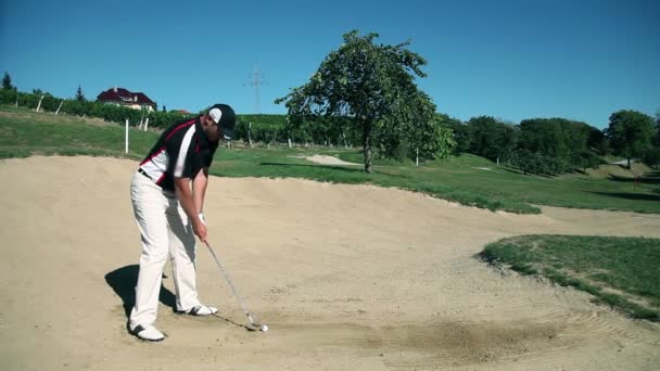 Schot van een man golfer op een zand golfbaan oefenen hits — Stockvideo