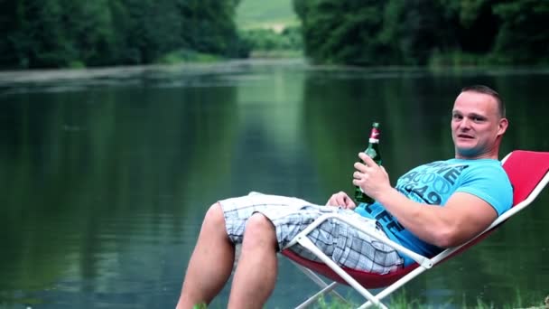 Jeune homme se détendre dans la nature et boire une boisson rafraîchissante — Video
