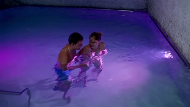 Coppia che esce da una piscina colorata — Video Stock