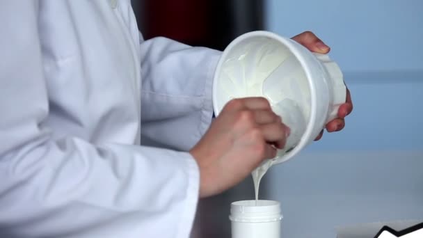 Close-up van de student handen maken crème — Stockvideo