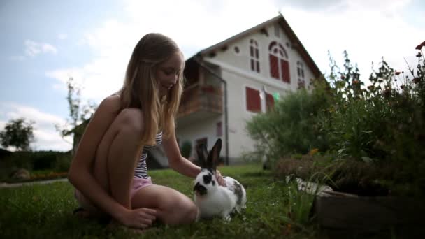 Ragazza adolescente accarezzare coniglio di fronte alla casa — Video Stock