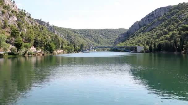 Prise de vue de la rivière krka avec un pont devant, faite à partir du bateau en mouvement — Video