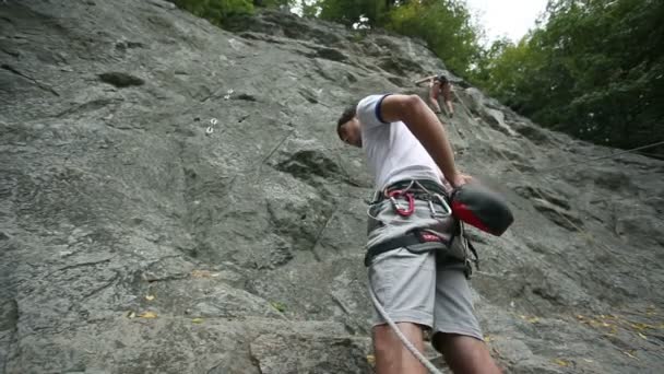 Hombre decidiendo escalar en roca en la naturaleza — Vídeos de Stock