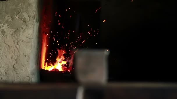 Close up slide shot of the furnace with sparkles and blacksmith — Stock Video
