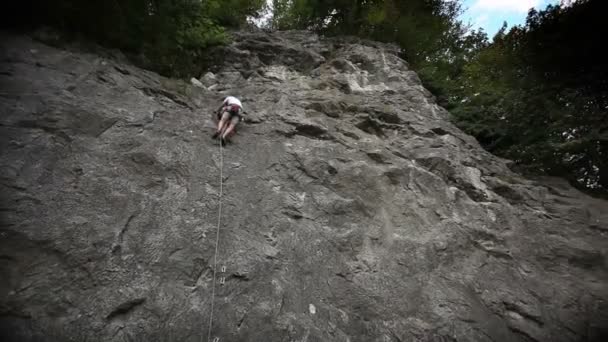 Uomo arrampicata su roccia sparato dal basso — Video Stock