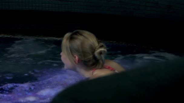 Donna sexy in una vasca idromassaggio colorata — Video Stock