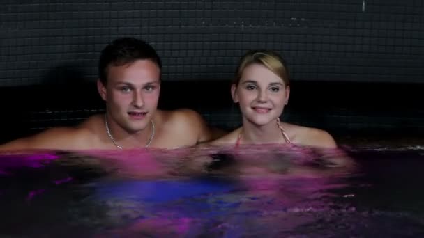 Couple in colorful jacuzzi — Stok video