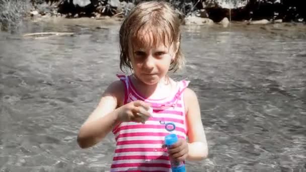 Cute girl blows soap bubbles — Stock Video