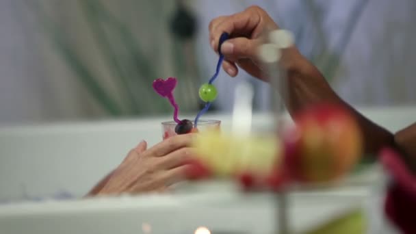 Primo piano di una coppia che mangia frutta nella vasca idromassaggio — Video Stock