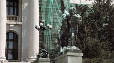 bir erkek ve bir at binanın önünde Yakınlaştır