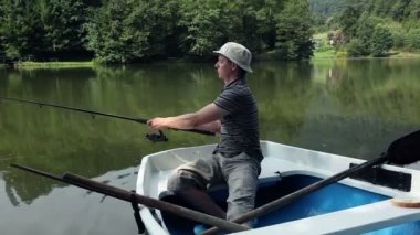 genç adam forest yakınındaki bir tekneden Balık tutma