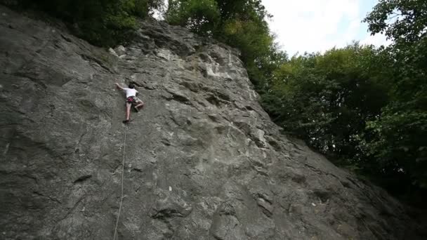 Mann klettert in schöner Natur von unten geschossen — Stockvideo