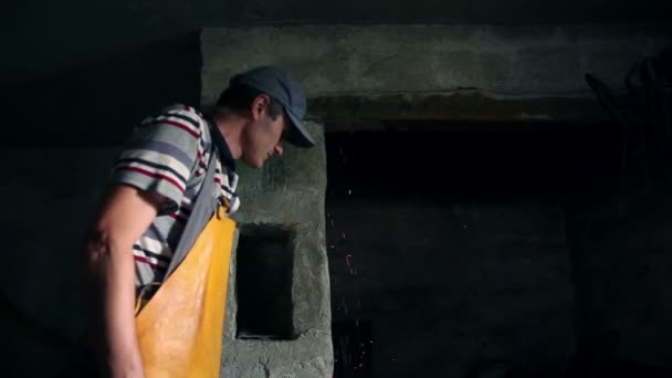 El herrero está soplando aire en el horno para obtener destellos — Vídeo de stock