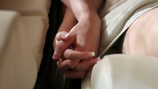 Para trzymając się za ręce w pokoju relaksu — Wideo stockowe