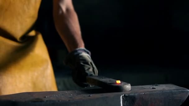 Close up slide shot of blacksmith who shapes metal into final shape — Stock Video