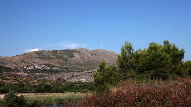 Panoramik çekim yel değirmenleri ile bir tepe ile Dalmaçya doğanın içinde arka plan — Stok video