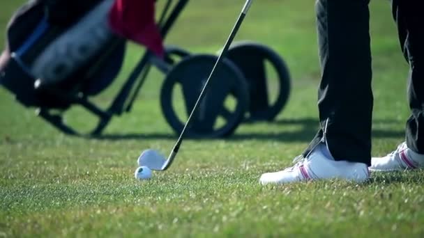 Primer plano en un campo de golf cuando un golfista golpea la pelota de golf blanca directamente a la sala — Vídeo de stock