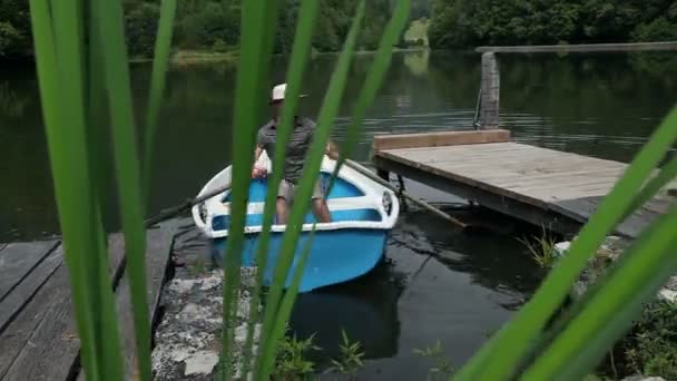 Joven en un barco preparándose para la pesca — Vídeos de Stock