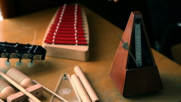 Zavřete záběr pracovní metronom a anonymní ruce, že hra na xylofon — Stock video