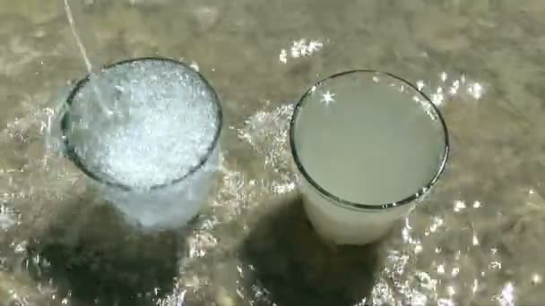 Gelas dengan air bersih dan berlumpur . — Stok Video