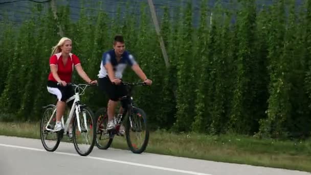 Young couple cycling in the country of hops — Stock Video