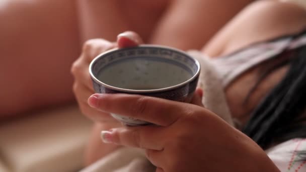 Молодая женщина пьет чай — стоковое видео