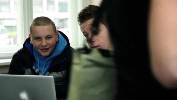 Два ученика в школьной столовой разговаривают и смотрят в компьютер — стоковое видео