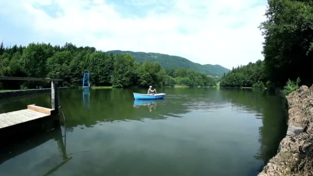 Jeune homme pêchant sur un bateau dans une belle nature — Video