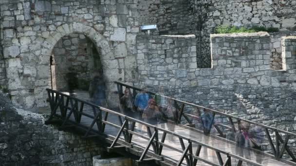 Shot of people looking like ghosts walking on bridge of fortress — Stock Video