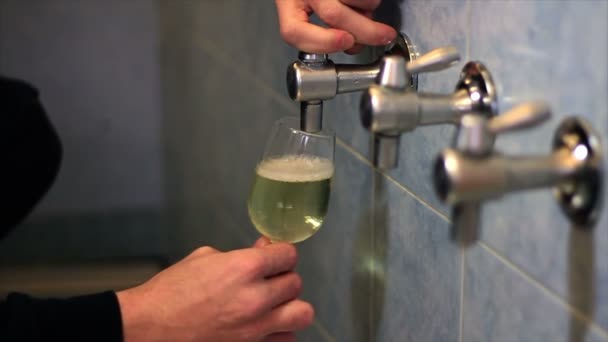 Крупный план руки мужчины, наливающего белое вино в стакан — стоковое видео