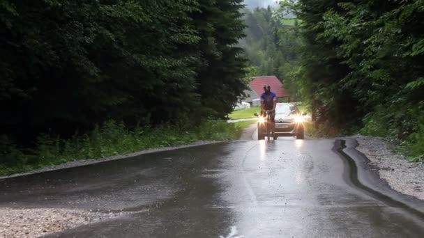 Sluit shot van de fietser op de weg folowed door een auto — Stockvideo