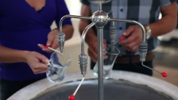 Close up shot of a young beautiful couple when pouring mineral water in special glass — Stock Video