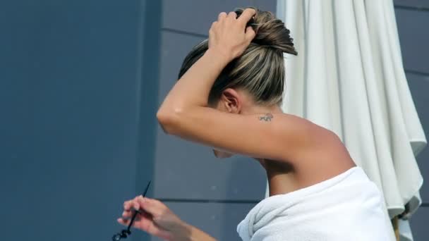 Женщина чинит свои длинные волосы — стоковое видео