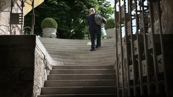 Tiro de jovem mulher saindo e pegando algo das escadas — Vídeo de Stock