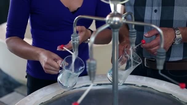 Primer plano de una joven pareja hermosa cuando se vierte agua mineral en un vaso especial — Vídeos de Stock