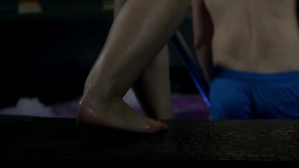 Молодая женщина сзади, когда она входит в бассейн — стоковое видео