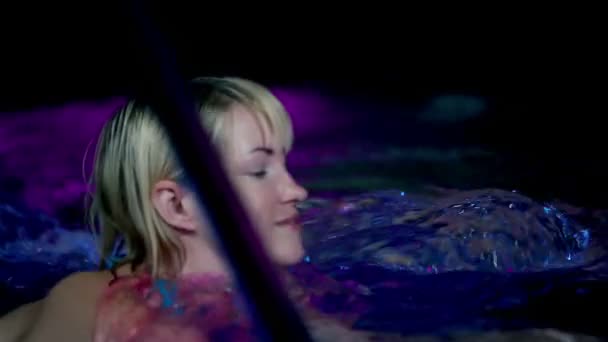 Pohledný mladý muž v barevné bazénu s bublinami — Stock video