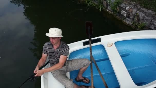 Jonge man visserij vanaf een boot schot van bovenaf — Stockvideo