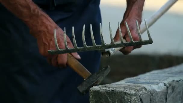 Старий ремонтує дерев'яні граблі — стокове відео