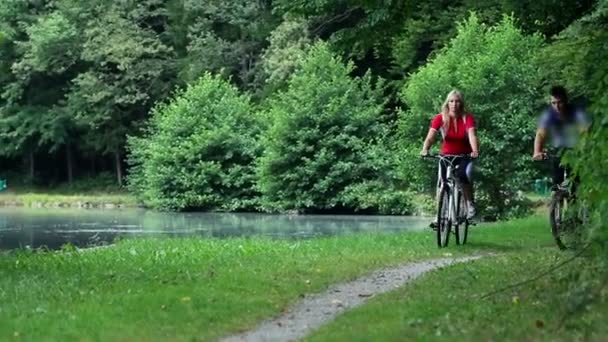 Jovem casal de ciclismo na natureza — Vídeo de Stock