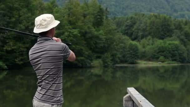 Jovem pesca em uma bela natureza — Vídeo de Stock