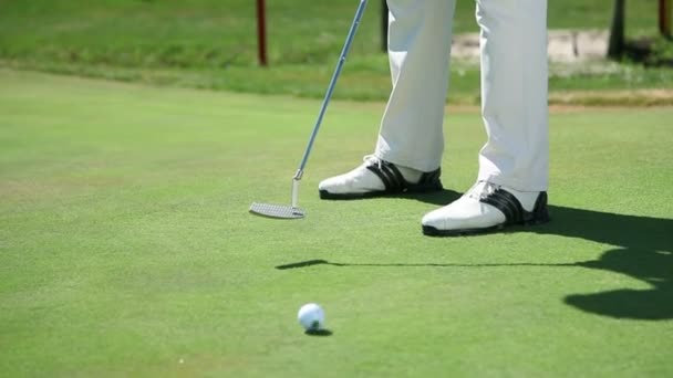 Крупный план на поле для гольфа, когда игрок в гольф попадает белый мяч для гольфа прямо в зал — стоковое видео